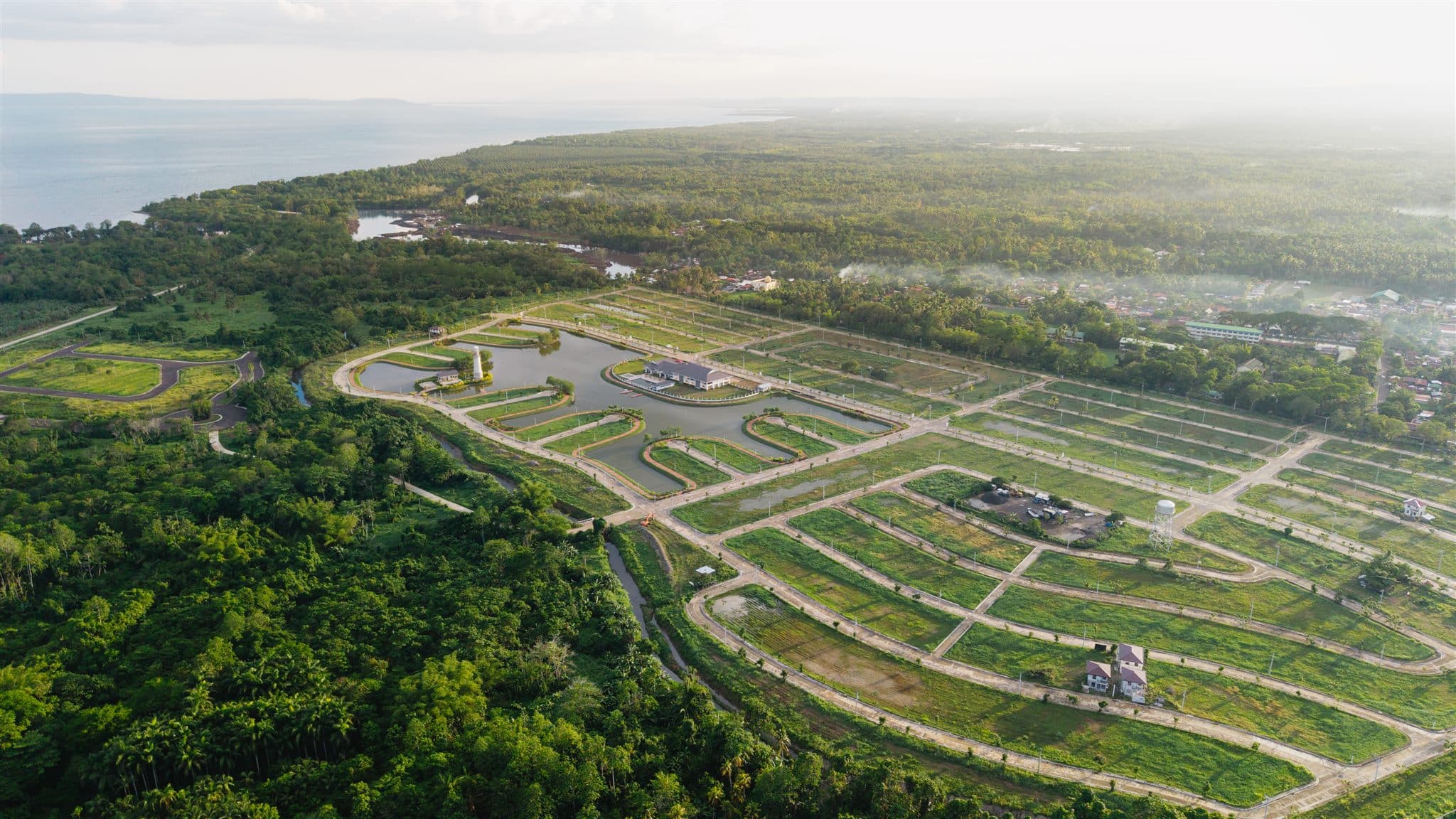 Aerial view of Los Rayos Lake Residences, a lakeside residential community surrounded by greenery