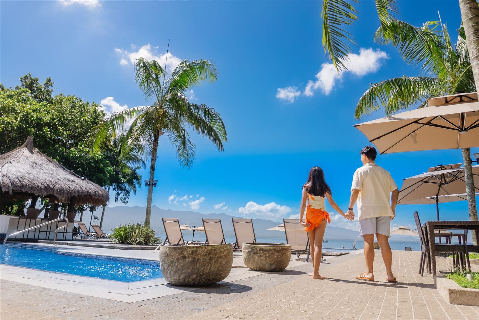 Couple walking past the beachfront pool at Hijo Resorts Davao
