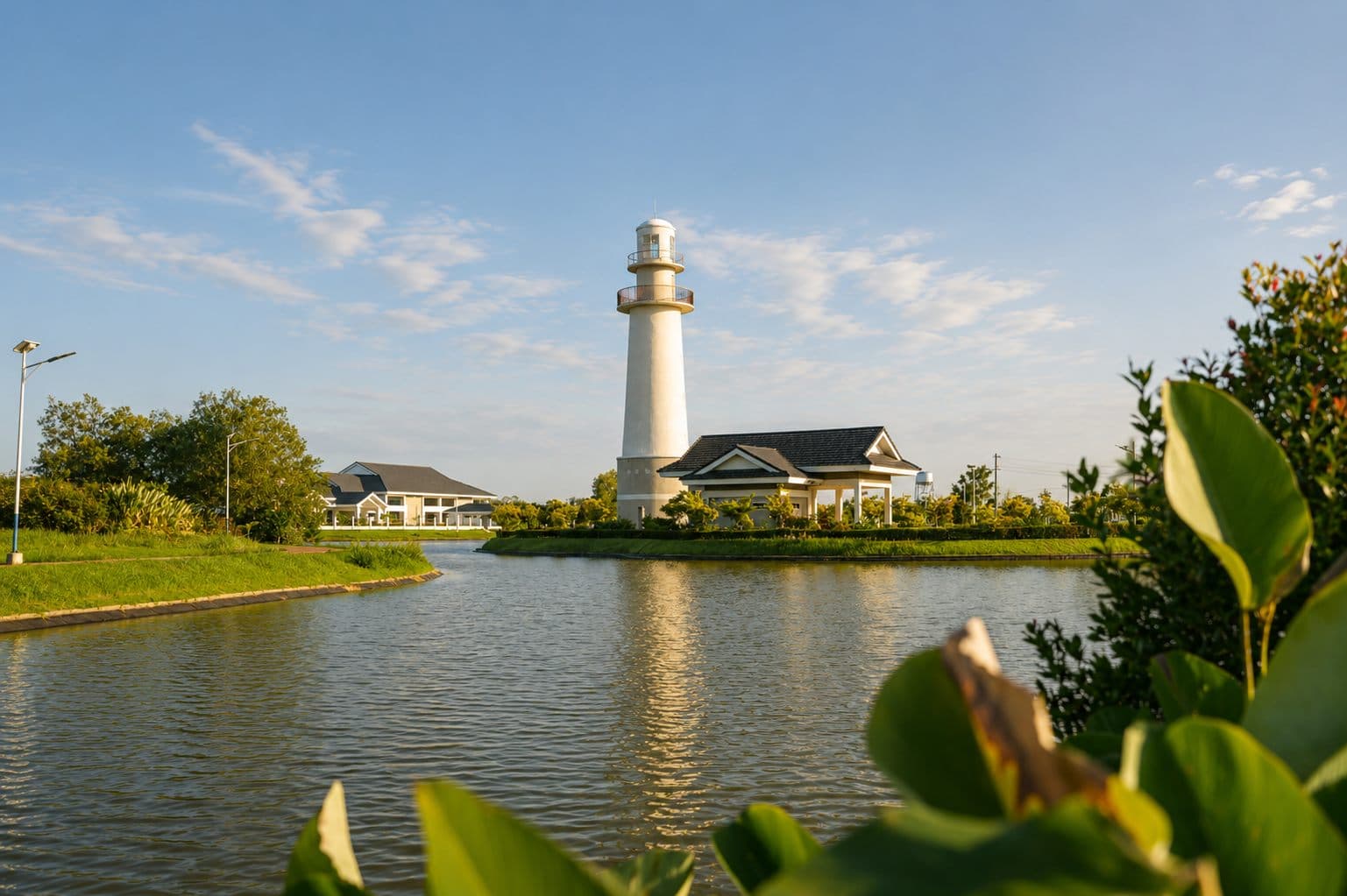 Lighthouse and a two-storey house beside a lake