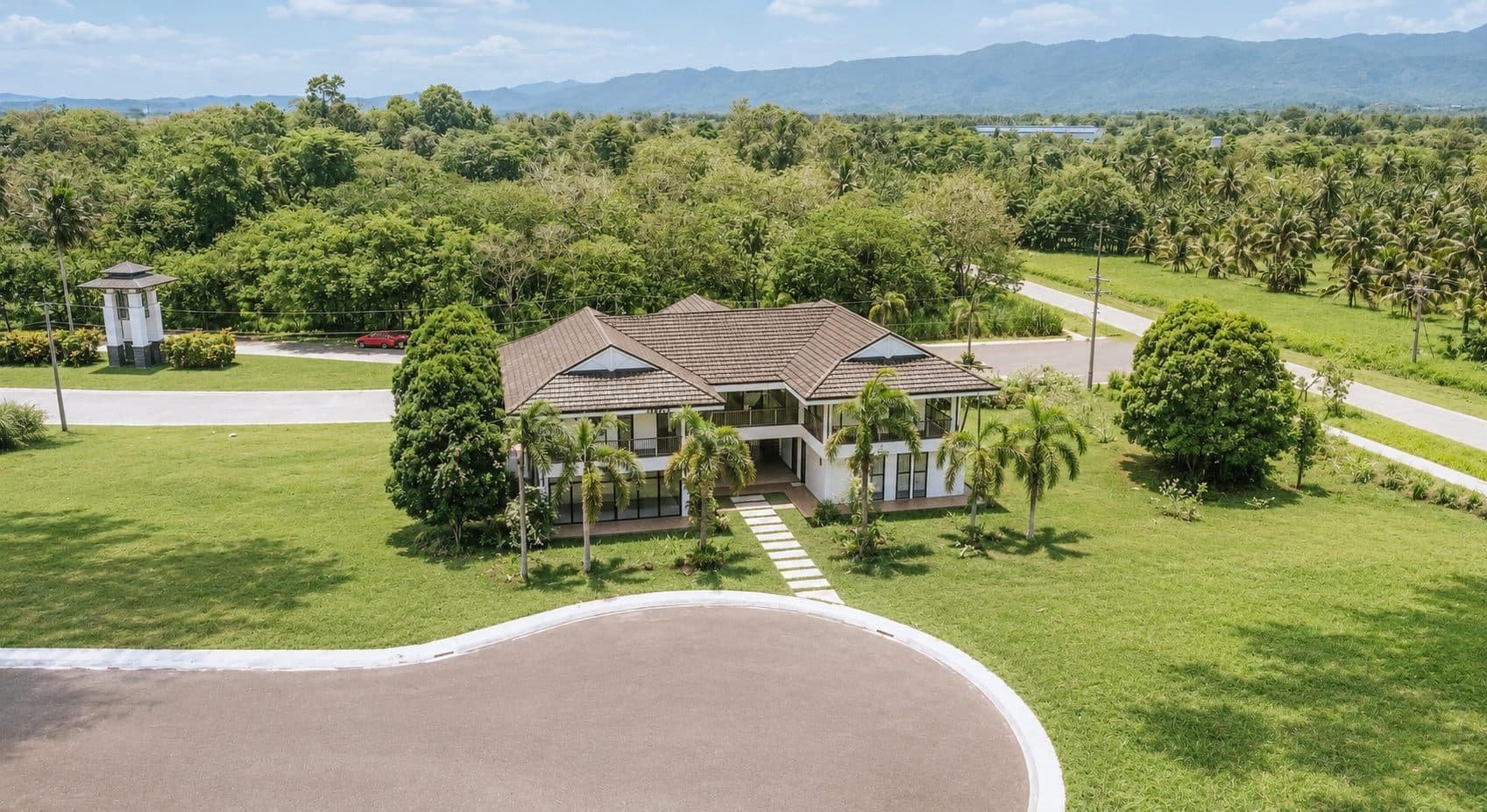 Aerial view of a two-storey villa within a plantation
